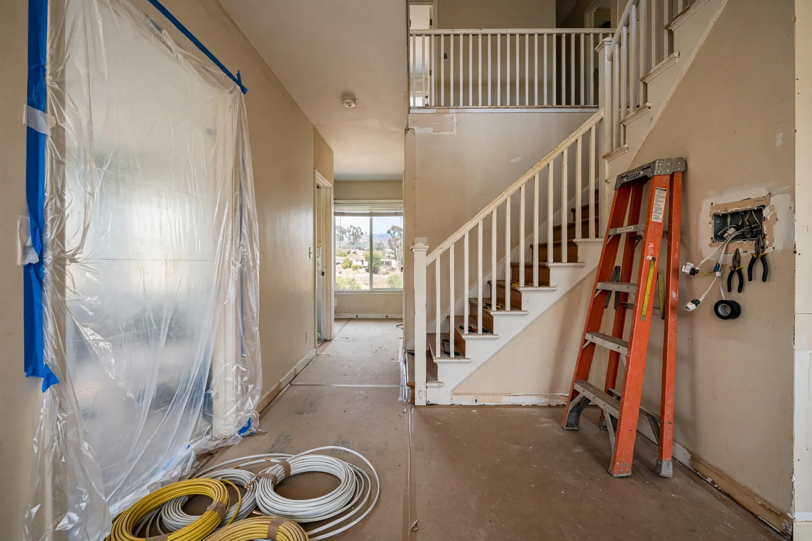 Room by room rewiring progress in an occupied two story home with protective floor coverings